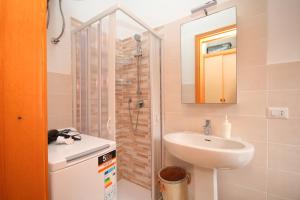 een kleine badkamer met een wastafel en een douche bij Casa Sciusca in Cefalù