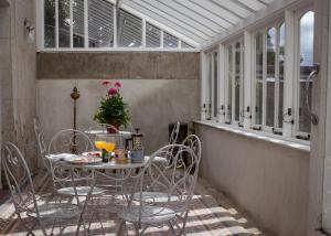 a table and chairs on a porch with windows at Mountrothe House in Kilkenny