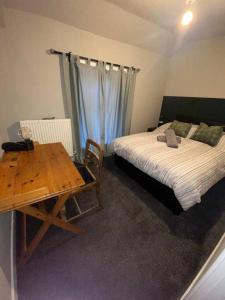 a bedroom with a bed and a desk and a table at Mountain View in Llwyn-y-pia