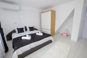 a bedroom with a large bed with two towels at WhiteBoxApartment in Kyustendil