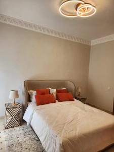 een slaapkamer met een groot bed met 2 oranje kussens bij Charmant appartement in Marrakesh