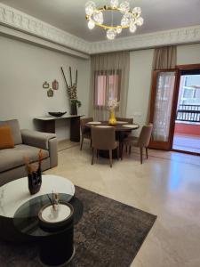 een woonkamer met een bank en een tafel bij Charmant appartement in Marrakesh
