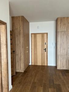 an empty room with wooden doors and wooden floors at Boszkowo Horizon Park in Boszkowo-Letnisko