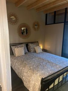 1 dormitorio con cama con almohadas y espejos en Casa Fuori, en Oirschot