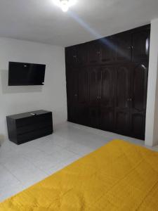 a bedroom with black doors and a yellow blanket at Alojamiento con 4 habitaciones Veracruz in Veracruz