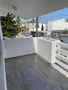 a balcony with a white wall and a wooden floor at Alojamiento con 4 habitaciones Veracruz in Veracruz