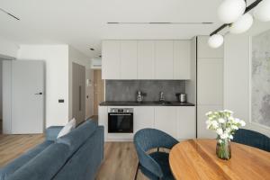 a kitchen and living room with a table and chairs at No. 1 PARK AVENUE APARTMENT in Kaunas