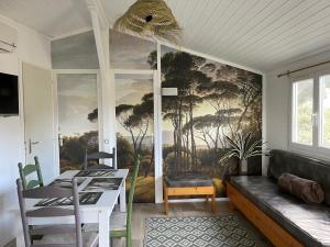 a dining room with a painting on the wall at Chalet T3 4/6 personnes à Agde in Agde