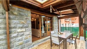 a dining room with a stone wall and a table and chairs at Casa Las Xanas in Llanes
