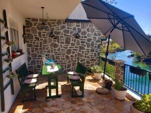 a patio with a table and chairs and an umbrella at Apartman Flumen in Mostar