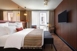 a hotel room with a large bed and a flat screen tv at Artizan - Design Hotel in Tbilisi City