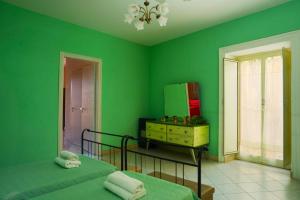 アグリジェントにあるGuglielmo's House Bed & Breakfastの緑のベッドルーム(ベッド2台、ドレッサー付)