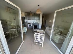 a living room with chairs and a table and a kitchen at APPARTEMENT Résidence RIVES D'EDEN in Sainte-Maxime