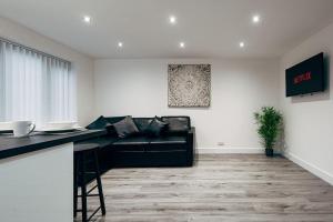 a living room with a black leather couch at Park & Relax in 1bd Central Liverpool home in Liverpool
