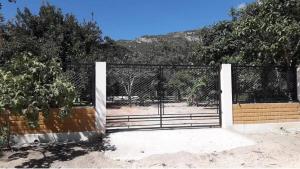 a gate with a fence in front of a field at Chalé Serra Santana in Cavalcante