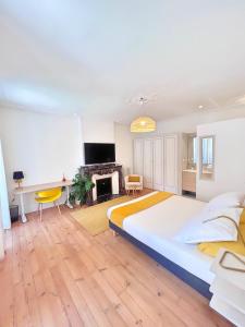 a large bedroom with a large bed and a fireplace at L'Elegant Paradoux - 3 sdb - 2 wc - Ascenseur - Parking - Plein Centre in Toulouse