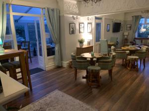 a living room with tables and chairs and a dining room at The Old Coach House in Blackpool
