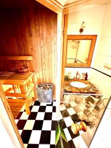 a bathroom with a sink and a checkered floor at Medieval unit with sauna in Tallinn