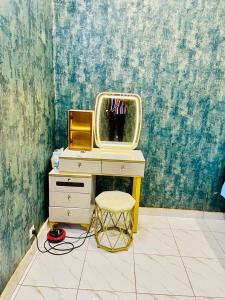 a room with a desk with a tv and a stool at Seïf Industry's in Ouagadougou