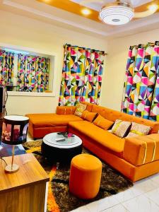a living room with an orange couch and chairs at Seïf Industry's in Ouagadougou