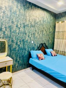 - une chambre avec un lit bleu et un bureau dans l'établissement Seïf Industry's, à Ouagadougou