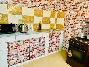 - une cuisine avec du carrelage rouge et blanc sur le mur dans l'établissement Seïf Industry's, à Ouagadougou