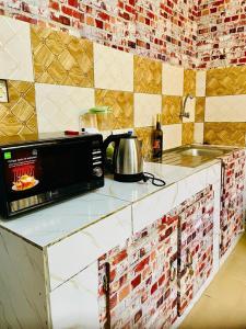 un four micro-ondes installé au-dessus d'un comptoir de cuisine dans l'établissement Seïf Industry's, à Ouagadougou