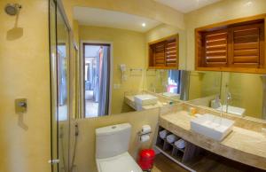 a bathroom with a toilet and two sinks and a mirror at Anexo à Pousada WindJeri in Jericoacoara +93 photos