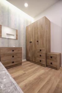 sypialnia z drewnianymi komodami i łóżkiem w obiekcie Kvartira dizaynerskaya w Erywaniu