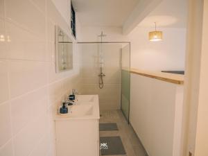 Un baño blanco con lavabo y ducha. en East Lodge appartement, en Sainte-Luce 11 fotos más