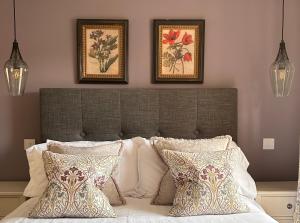 a bedroom with a bed with two pictures on the wall at The Cottage in Dunblane