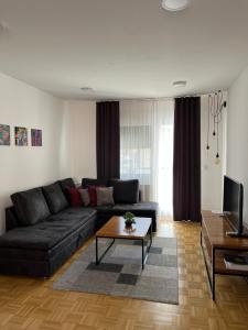 a living room with a black couch and a coffee table at For5 in Đakovo