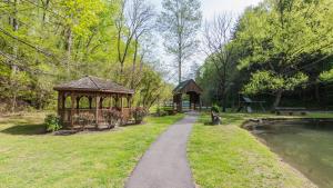 a path in a park with a gazebo next to a river at Windsong in Sevierville