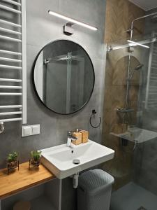 a bathroom with a white sink and a mirror at Apartament Grabówek in Gdynia