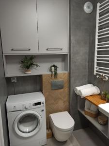 een badkamer met een wasmachine en een toilet bij Apartament Grabówek in Gdynia