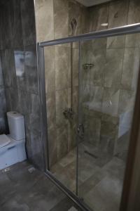 y baño con ducha y puerta de cristal. en Sun Bella Konaklama en Kırklareli