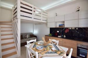 a room with a dining table and a loft bed at Mare Arcobaleno in Marzamemi