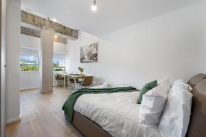 a white bedroom with a bed and a dining room at Stylish 1BR Retreat at Station House Milton Keynes in Milton Keynes