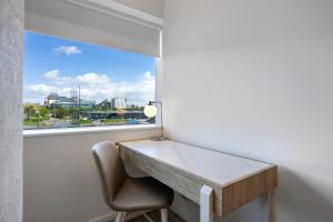 uma mesa e uma cadeira num quarto com uma janela em Stylish 1BR Retreat at Station House Milton Keynes em Milton Keynes
