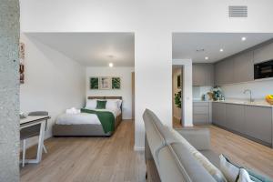 um quarto e sala de estar com uma cama e uma cozinha em Stylish 1BR Retreat at Station House Milton Keynes em Milton Keynes