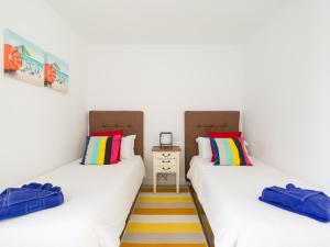 two twin beds in a room with colorful pillows at Villa Bonita in Playa Blanca