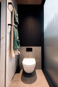 a bathroom with a white toilet and green towels at Ewe and Me Glamping in Northallerton