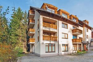 an apartment building with balconies and trees at Moniuszki, Sun & Snow in Karpacz
