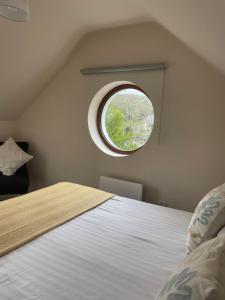 a bedroom with a large bed with a round window at Shindilla Cottage Air B&B in Galway