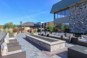 a patio with couches and benches in front of a building at New Lake Como Condo with Lake Views in Lake Geneva