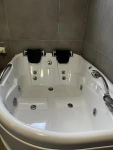 a white bath tub with two black towels in it at Freiblick 3 Bad Glbg mit Terrasse Top 3 in Bad Gleichenberg