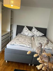 Un dormitorio con una cama con almohadas. en Freiblick 3 Bad Glbg mit Terrasse Top 3, en Bad Gleichenberg