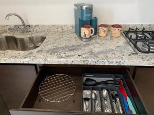 a drawer with utensils in it under a kitchen counter at Comfortable Modern Stays provided by Hidden Gem Vacation Homes in Zapotlanejo +19 photos