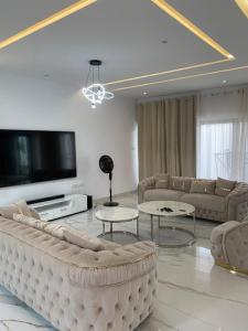 a living room with couches and a flat screen tv at Luxe Dandji in Cotonou