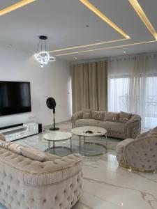 a living room with couches and a flat screen tv at Luxe Dandji in Cotonou